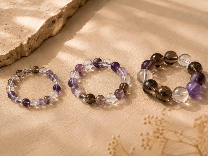 Crystal beads in 8mm 10mm and 12mm sizes arranged on a warm neutral surface