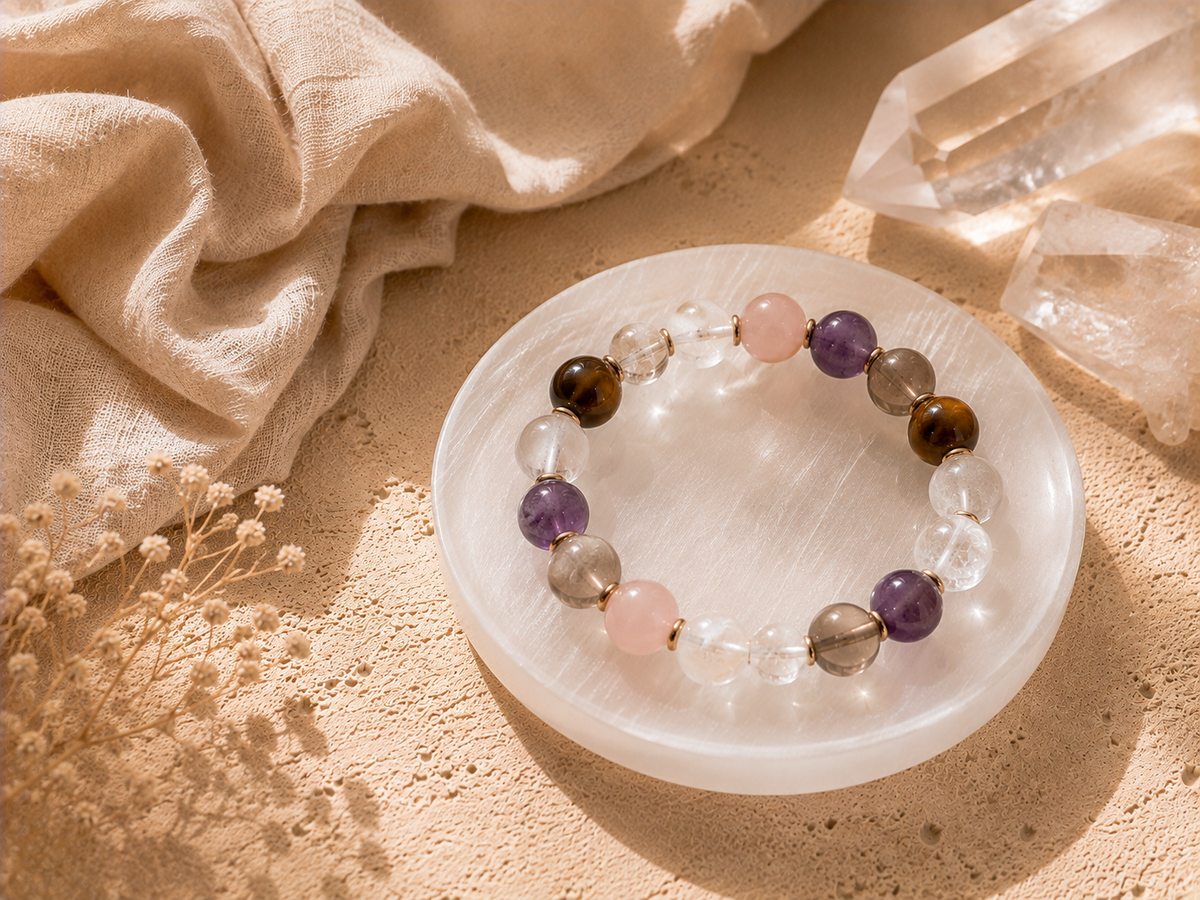 Crystal bracelet resting on a selenite plate with clear quartz and soft linen for cleansing